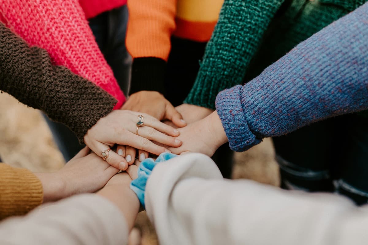 A group of women stacking their hands together in a circle