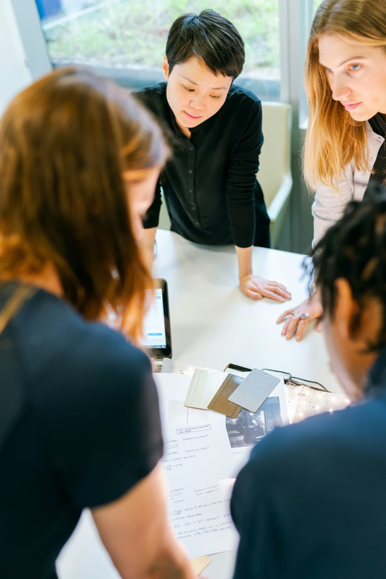 A group of colleagues gathered around a table, reviewing planning materials together
